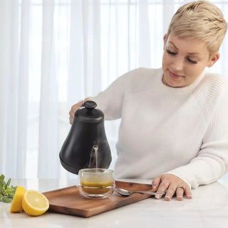 Woman pouring G.I. InnerCalm into a glass cup.